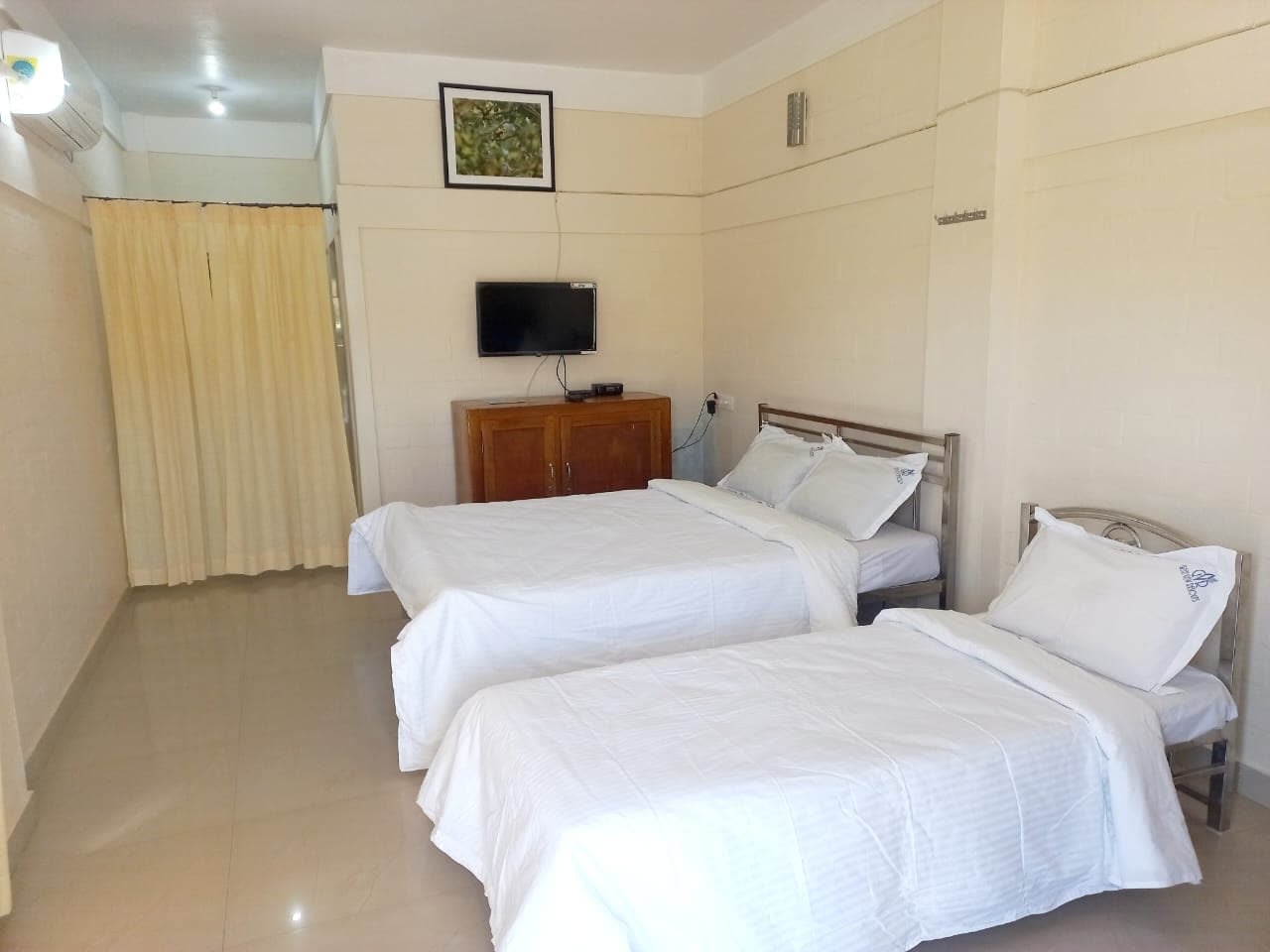 Twin bed AC room with television at Green View Homestay